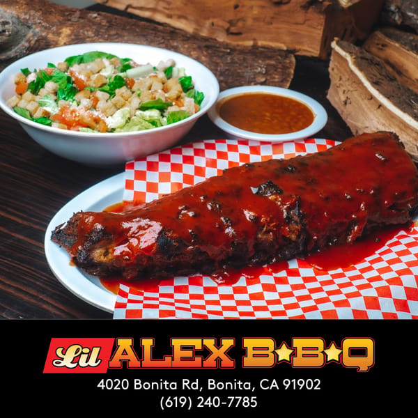 Lil Alex BBQ ribs with sauce, a side salad, and baked beans on a checkered paper.