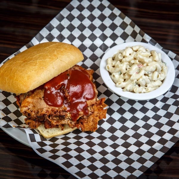 Lil Alex BBQ pulled pork sandwich with barbecue sauce and a side of macaroni and cheese.